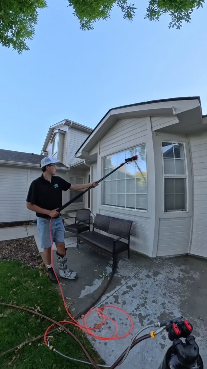Daiken cleaning home windows with a water-fed pole in the Treasure Valley