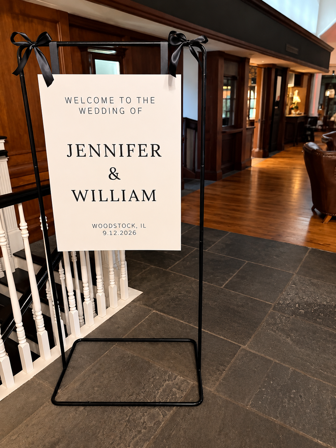 Black welcome sign stand with satin ribbon accents