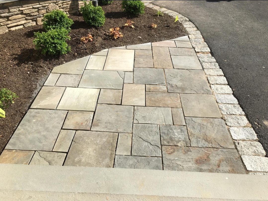 Poolside pavers being installed beside a curved retaining wall