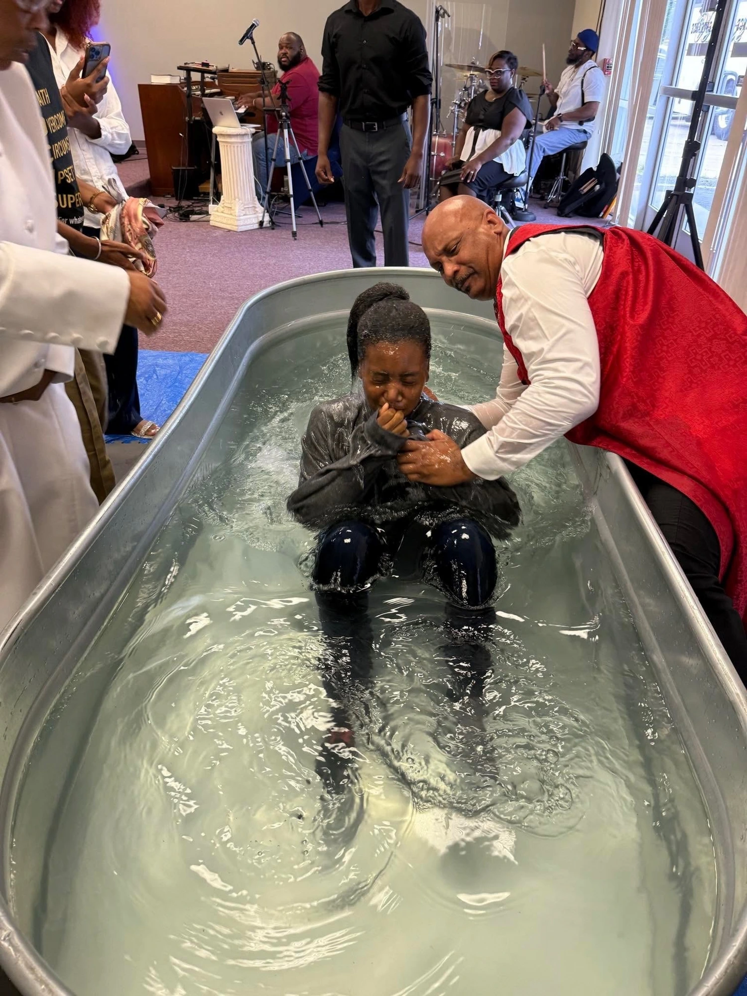 A believer being baptized during worship at Greater Faith