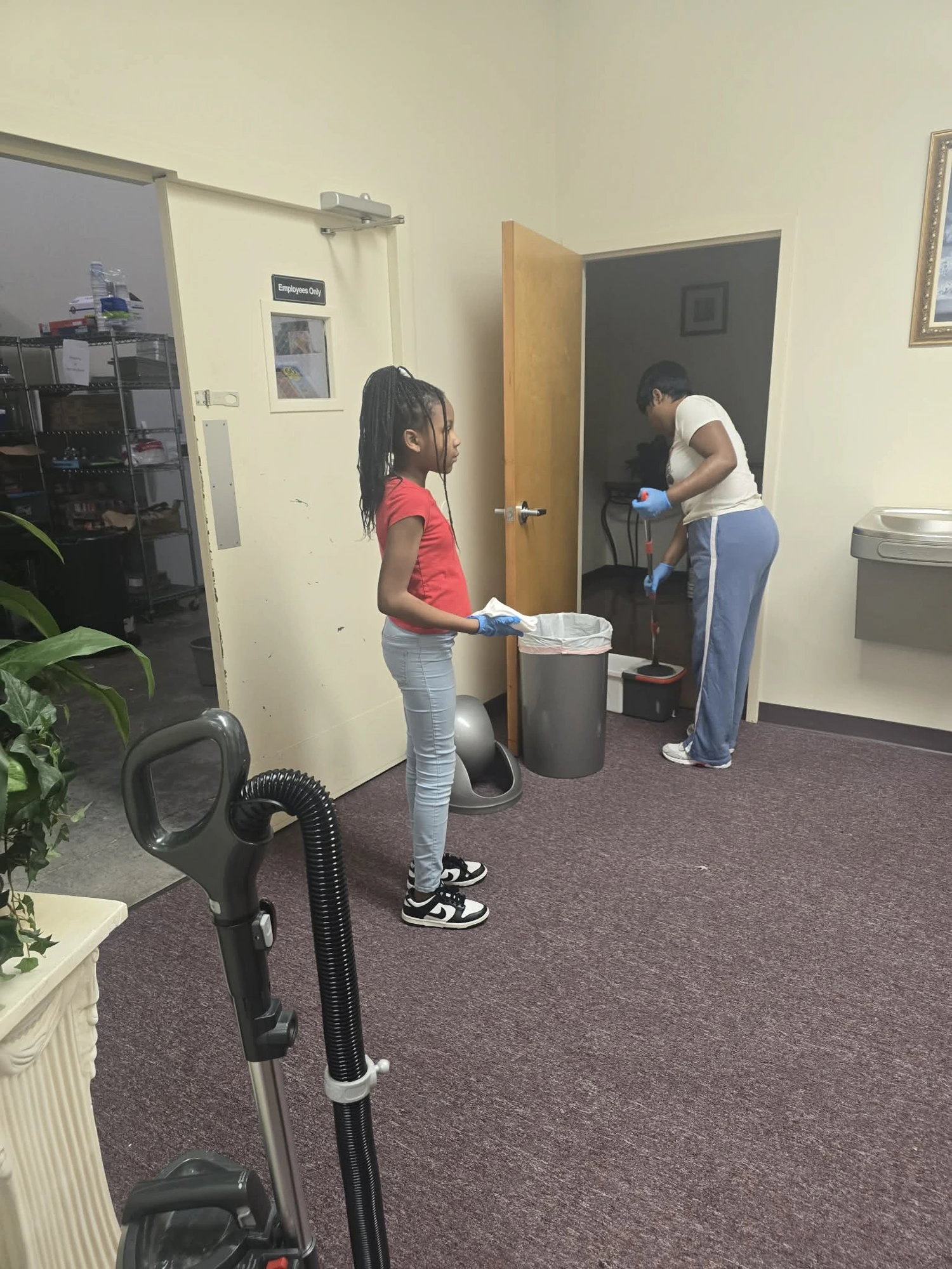 A young member and an adult serving and cleaning the ministry