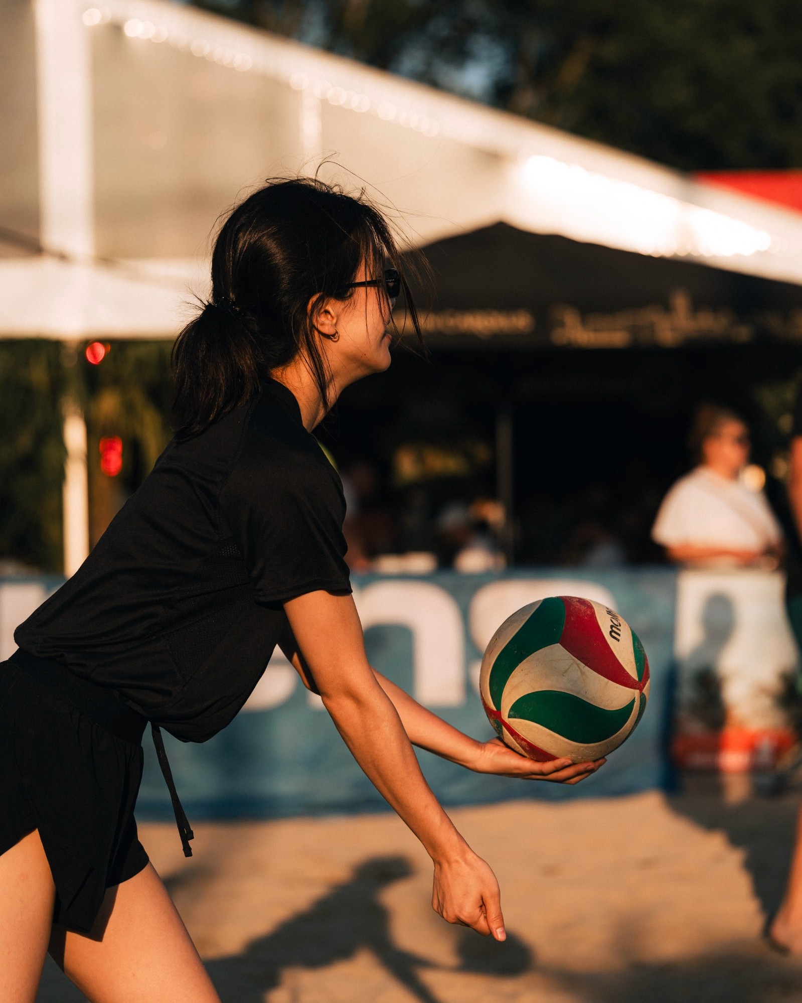 Sfeerbeeld Mechelen Beach 2026 — speler serveert bij gouden avondlicht