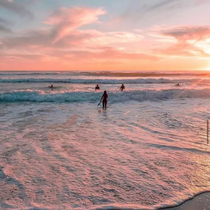Surfers heading down to the water at Kirra Beach