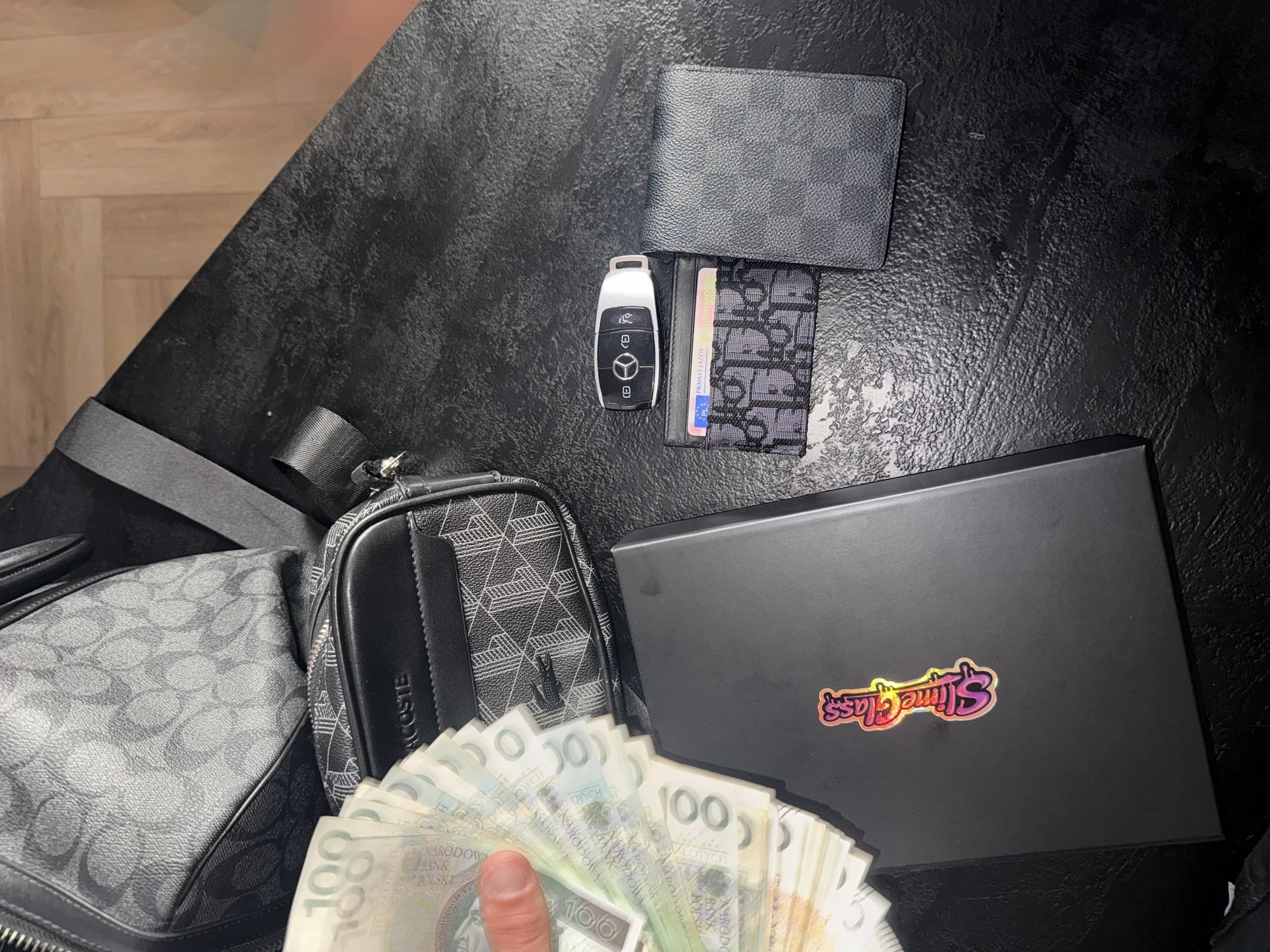 SlimeGlass box with Mercedes key, wallet and cash flat-lay